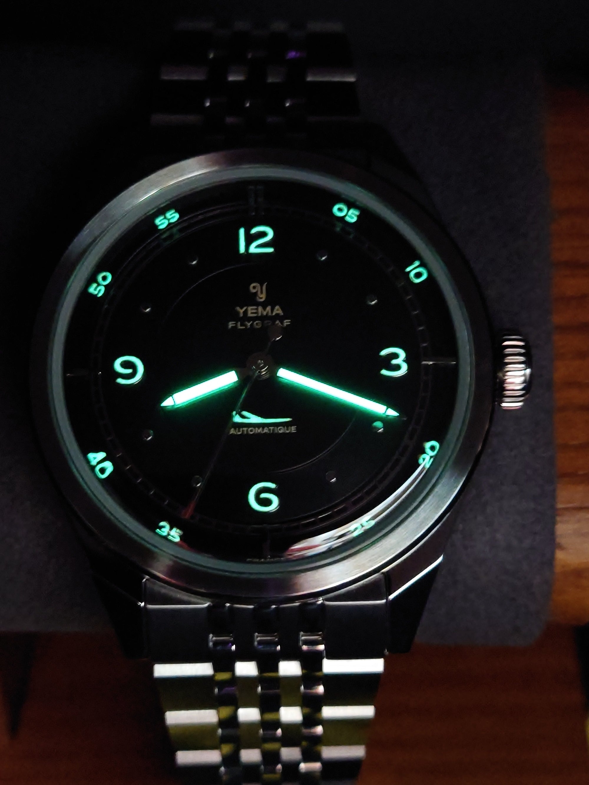 YEMA FLYGRAF Pilot automatic wristwatch with stainless steel bracelet and black dial display lume effect.